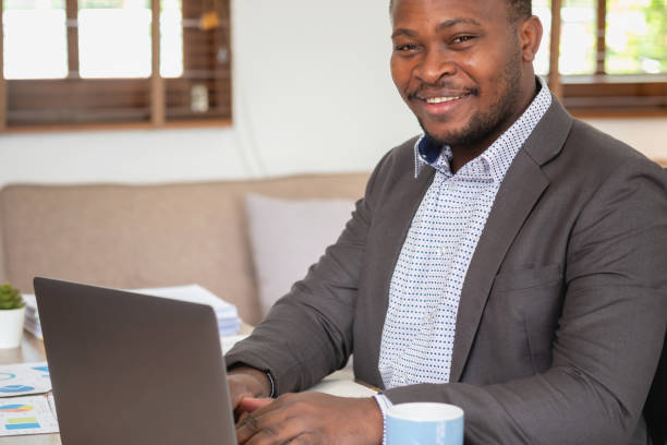 istock African American businessman analyzing laptop graph paperwork in office holding documents preparing portfolio analysis report Black male analyst doing paperwork in the workplace using the computer. 1484842562