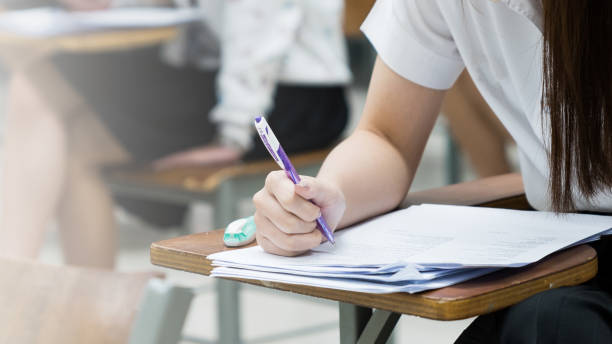 istock Asian college students concentrate on doing examinations in the classroom. Education stock photo 1484842714