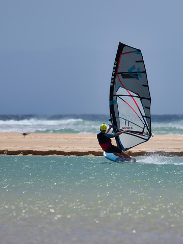 Jandia, Spain - June 17, 2022: The Sotavento it's a beautiful beach on the island of Fuerteventura, with clear sand and shallow turquoise waters. The strong wind makes it the ideal setting for windsurfing.