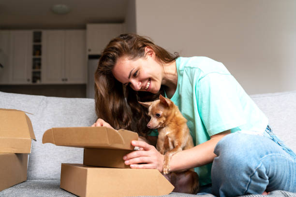 istock Woman and her lap dog together unboxing postal parcels. 1484845436