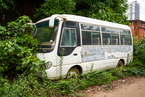 An old minibus passenger car parked in an abandoned industrial park