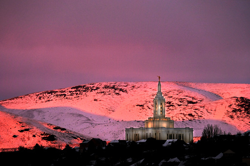 Pocatello LDS Mormon Temple in winter at sunset with golden orange light on snow