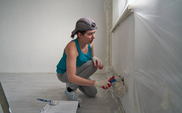 istock Woman paints the wall with a roller 1484852421