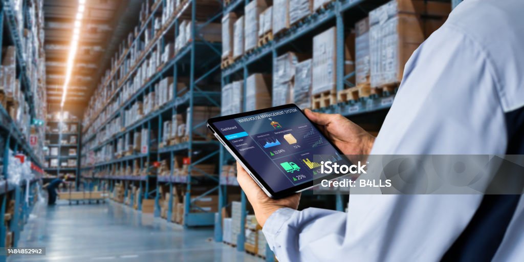 Smart Warehouse,Inventory management system concept. Manager using digital tablet,showing warehouse software management dashboard on blurred warehouse as background Freight Transportation Stock Photo