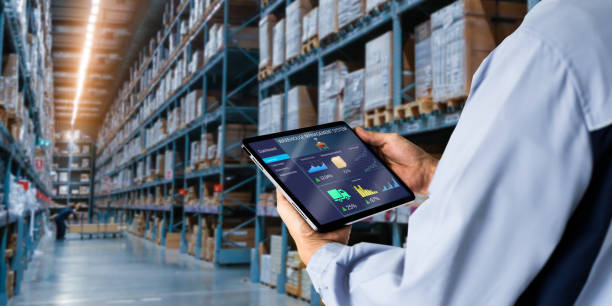 Smart Warehouse,Inventory management system concept. Manager using digital tablet,showing warehouse software management dashboard on blurred warehouse as background Warehouse stock pictures, royalty-free photos & images