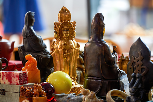 Close-up of metal bodhisattva buddha statues sold in the market