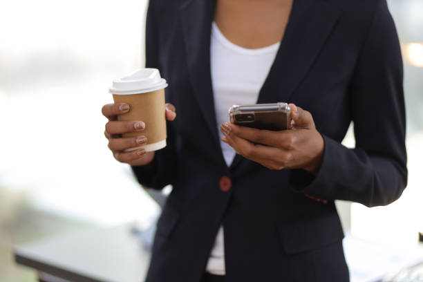 istock Businesswoman drinking coffee using smartphone is texting. 1484855264