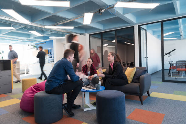 istock Multiethnic startup business team on meeting in a modern bright open space coworking office. Brainstorming, working on laptop. Group of coworkers walking around in motion blur. 1484855471