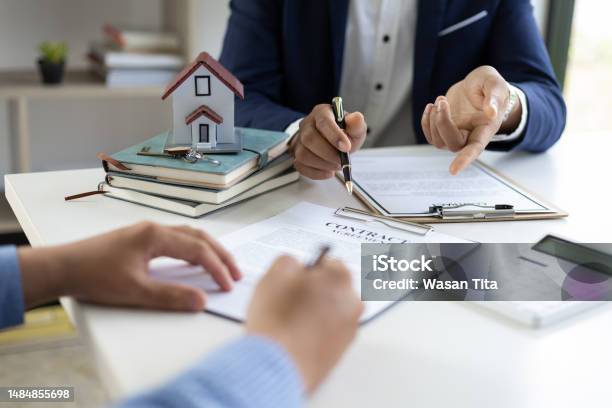 The Real Estate Agent Explaining The Terms In The Legal Real Estate Agreement Contract Document Waiting For Customer To Sign Mortgage Lease Home Insurance Concepts Stock Photo - Download Image Now