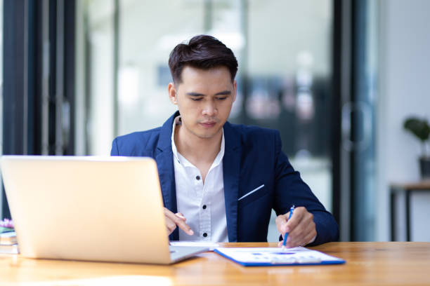 istock Businessman working on document on laptop in office. 1484855803