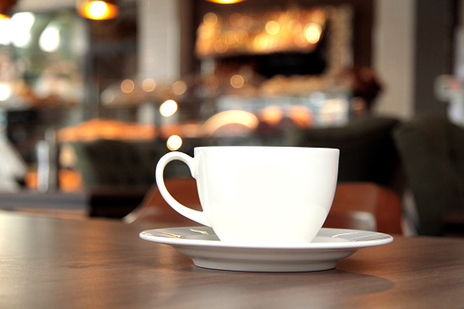 Coffee cup on the table in coffee shop background, stock photo