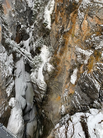 Aerial view of pristine winter landscape featuring snow covered rocky cliffs with white snow