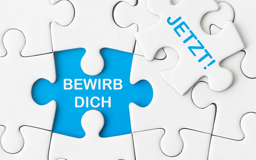 BEWIRB DICH - JETZT! - Text on white puzzle as template for vacancies, job posting and search