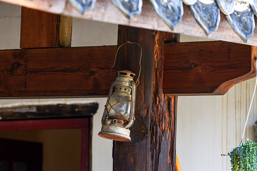 Close-up of a retro kerosene lamp hanging on a wooden stake