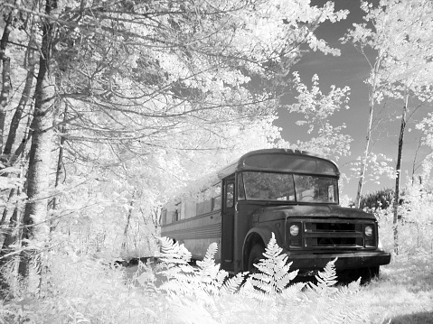 Vintage school bus converted to a camper photographed in infrared.