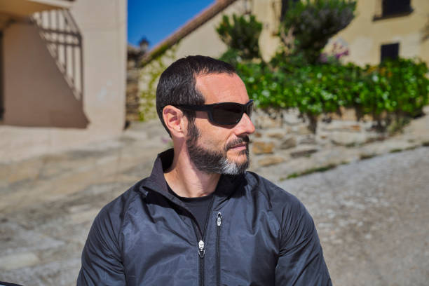 MAN WITH SUNGLASSES LOOKING TO THE SIDE ON A SUNNY DAY