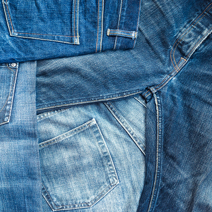 A square format background of blue denim jeans.