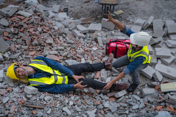 istock Young Asian builder falls from a height at a construction site. An engineer supervising the construction came to the aid of a construction worker who fell from a height with knee and leg injuries. 1484868387