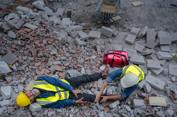 Young Asian builder falls from a height at a construction site. An engineer supervising the construction came to the aid of a construction worker who fell from a height with knee and leg injuries. joven constructor asiático cae desde una altura en un sitio de construcción. un ingeniero que supervisaba la construcción acudió en ayuda de un trabajador de la construcción que cayó desde una altura con lesiones en la rodilla y las piernas.