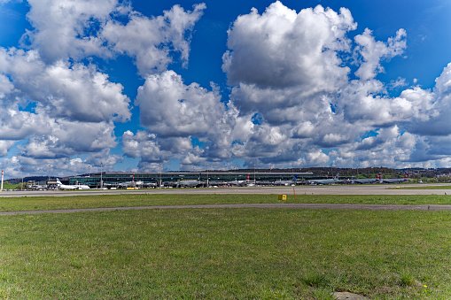 Parked airplanes at terminal Dock Midfield at Swiss Airport Zürich Kloten on a sunny spring day. Movie shot April 14th, 2023, Kloten, Canton Zurich, Switzerland.