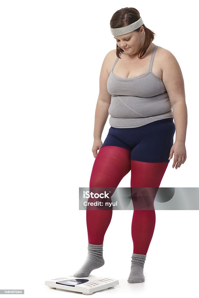 Fat woman stepping on scale Fat woman in sportswear stepping on scale with fear...  One Person Stock Photo