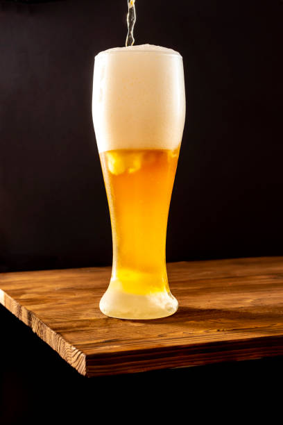 istock Light craft beer in a misted glass on a wooden table. 1484871170