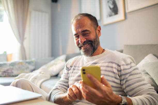 istock Mid adult man using a smart phone at home 1484874414