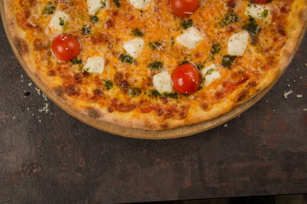 istock pizza with tomato and cheese on the rusty background 1484876261