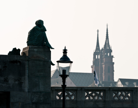 Quiet scene at the head Middle Bridge at Rhine river. Helvetia, old lantern and the Munster Cathedral in the background.