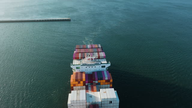 Aerial close-up. Tugs tow a container ship into a harbour.Global supply chain.Logistics.Distribution