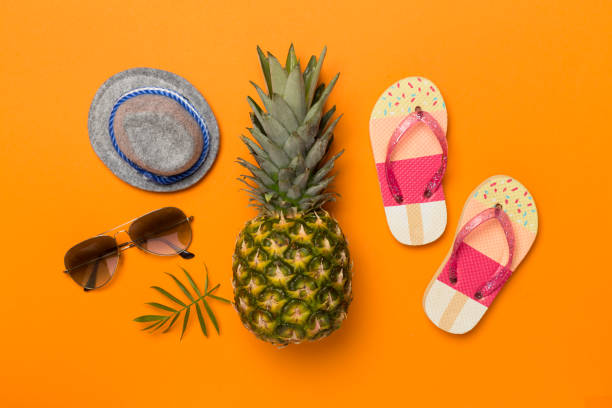 Creative pineapple hipster in sunglasses on color background, top view
