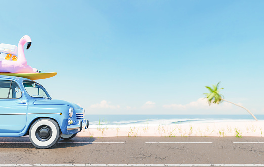 3D rendering of retro car with surfboard and inflatable flamingo tube on roof parked on asphalt road near sandy beach washed by foamy sea against cloudless blue sky