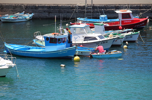 El Cotillo, Spain - May 10, 2023: Fishing boats moored in the harbour of El Cotillo in Fuerteventura. Canary Islands, Spain