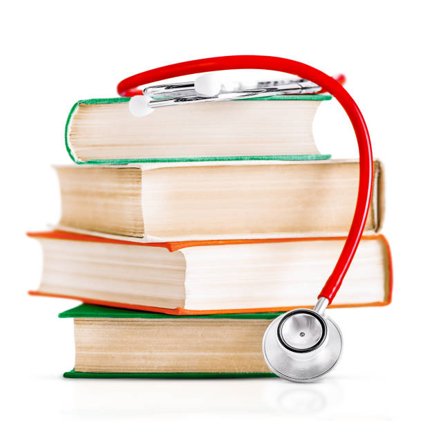 赤い聴診器は厚い古い本の上に横たわっています。白い背景で強調表示 - book book cover healthcare and medicine medical exam ストックフォトと画像