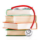 the red stethoscope is lying on thick old books. highlighted on a white background