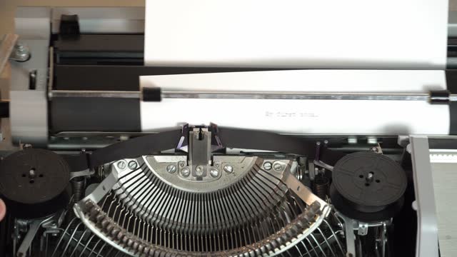 Writing a book and typing old typewriter, top view. Man typing on old vintage retro typewriter. News, media or communication concept