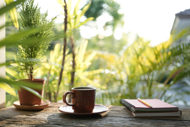 istock spiral notebook and wooden coffee cup on wooden table with greenery scene 1484891840