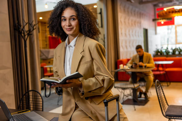 istock Curly-haired well-dressed woman with a notebook in hand 1484893996