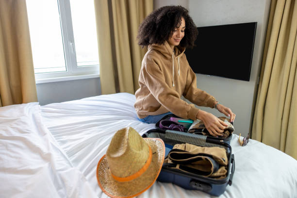 istock Curly-haired pretty young woman packing her suitcase 1484894164