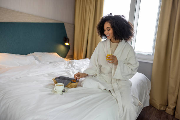 istock Cute young woman in white bath robe having breakfast 1484894233