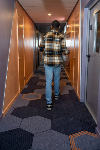 In the hotel. Young man in a plaid shirt in a hotel corridor
