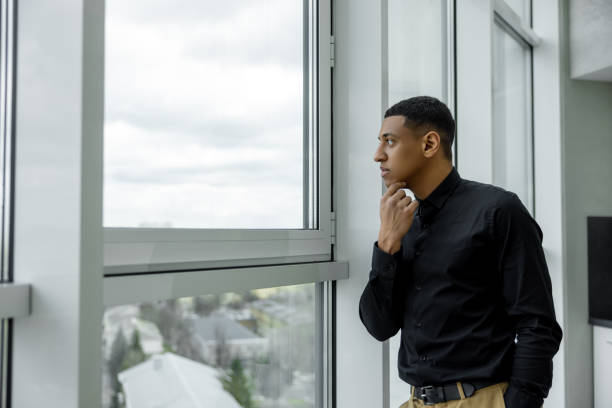 istock Thoughtful young man standing near the window 1484894391