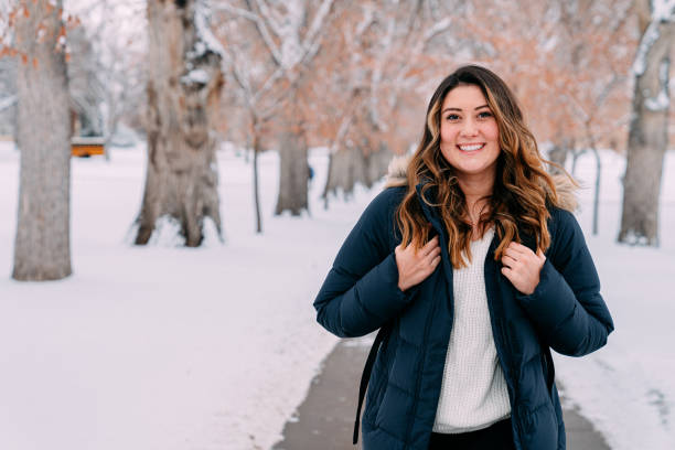 istock Cute Portrait of a Cheerful University Student Standing Holding Her Backpack Straps Looking at Camera on Campus on a Snowy Day in Colorado with Copy Space 1484901574