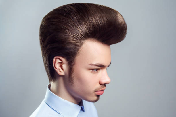 homem adulto jovem com bigode e barba com penteado pompadour clássico retrô, olhando para longe. - pompadour - fotografias e filmes do acervo