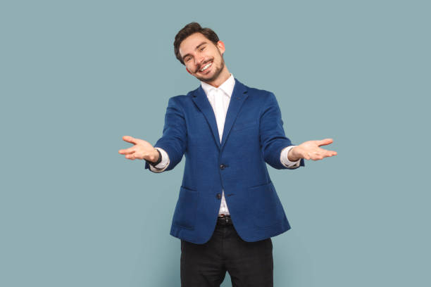 istock Friendly positive man with mustache standing with spread hands, saying welcome, take for free. 1484903786