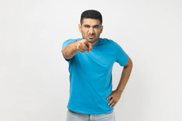 istock Serious unshaven man with hand on hip, pointing finger at camera, expressing negative emotions. 1484904612