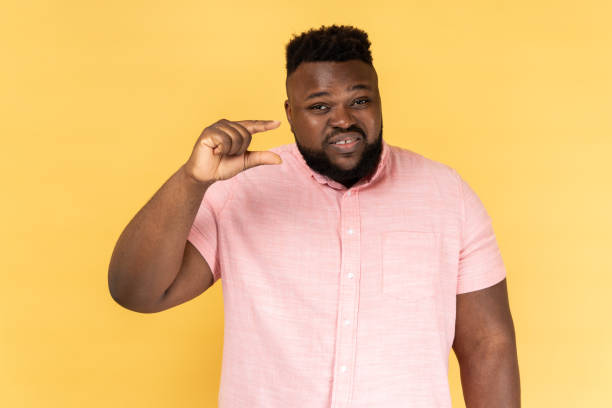 istock Man showing a little bit gesture and smirking at camera, measuring size, need more. 1484905754