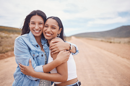 Portrait, hug and friends on a road trip with mockup on a dirt road outdoor in nature for adventure together. Desert, travel or freedom with a young woman and friend hugging outsode on holiday