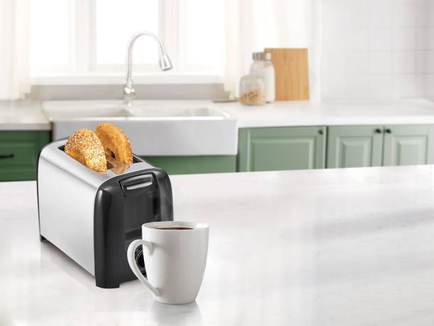 Coffee mug and a toaster with bagel in a kitchen
