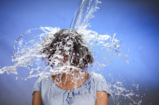 African american woman after splash of water from top.